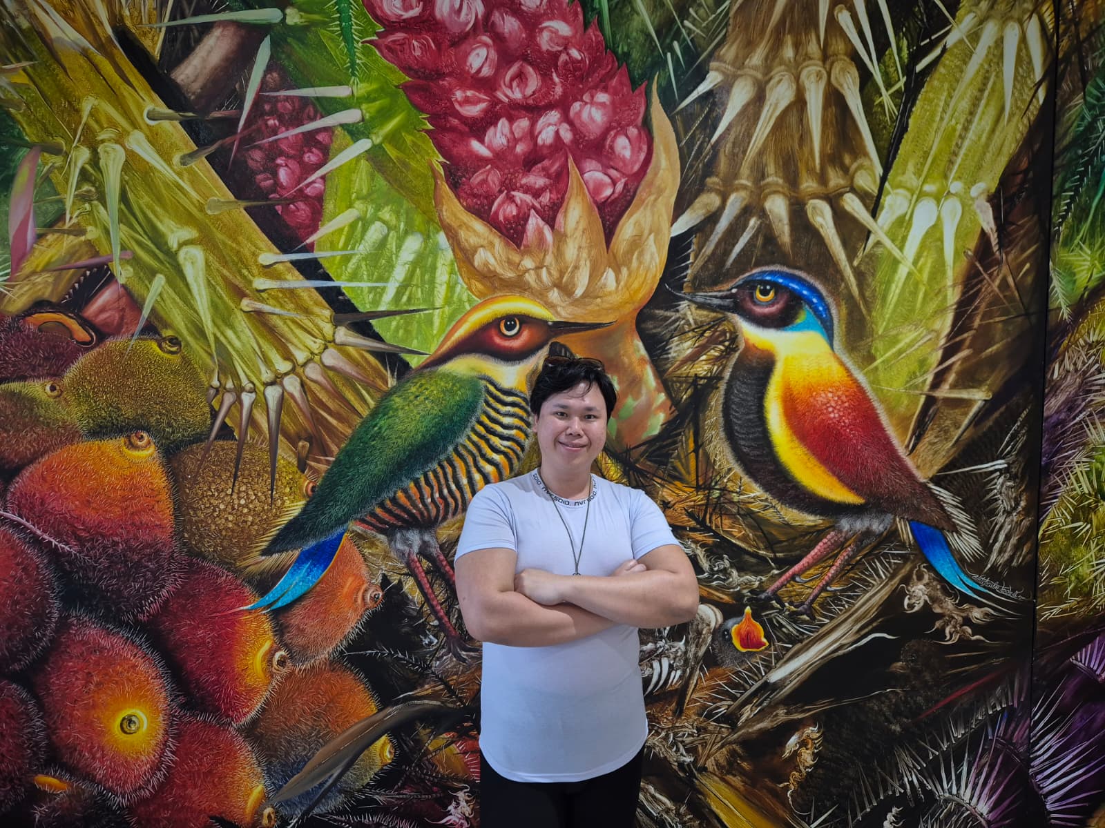 Faris Ridzuan, Lead Rasa Synthesiser at Freesheart™, before a painting by Watcharin Rodnit